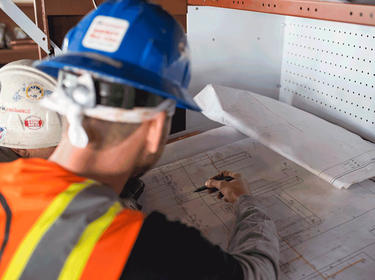 Construction workers reviewing blueprints