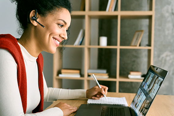 Mulher acompanhando uma sessão de treinamento online em seu laptop Mulher acompanhando uma sessão de treinamento online em seu laptop